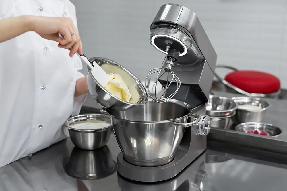 pastry chef adds butter to the mixer